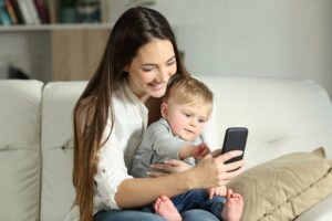 mutter mit ihrem baby am smartphone