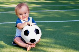 Kind mit einem Fußball in der Hand
