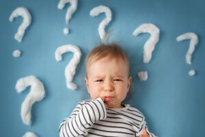unzufriedenes Baby mit Fragezeichen