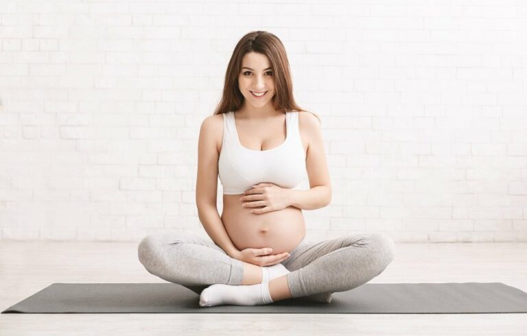 schwangere frau auf yoga matte