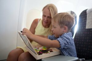 Mutter spielt zusammen mit ihrem Kind im Flugzeug ein Reisespiel